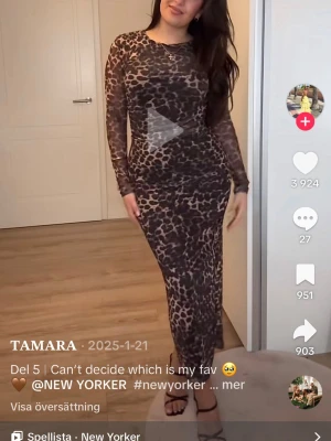 Leopardmönstrad långklänning New Yorker - Säljer en långärmad, figurnära långklänning från New Yorker med leopardmönster i bruna och svarta toner. Klänningen har rund halsringning och är tillverkad i ett stretchigt syntetmaterial som sitter snyggt på kroppen.