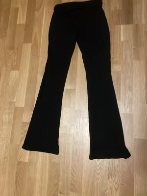 Svarta bootcut leggings - Säljer ett par svarta leggings med bootcut-modell och hög midja. De är stretchiga och sitter tajt upptill men har utsvängda ben. Perfekta till en avslappnad look och superbekväma att bära hela dagen.