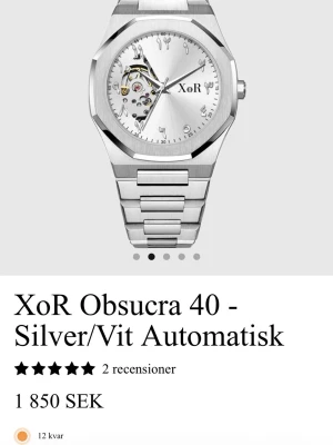 XoR Obsucra 41mm Silver/Grå HELT NY - Stilren klocka från XoR i borstat silverfärgat 316L rostfritt stål med unikt urverk synligt på urtavlan. Klockan har arabiska siffror, rund urtavla och länkarmband i metall. Kommer helt ny med originalbox. Plasten är på eftersom den är sprillans ny.