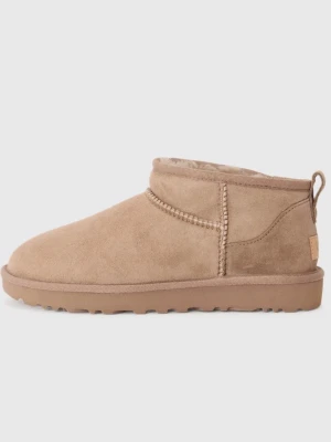 Beige UGG Classic Ultra Mini tofflor - Säljer ett par beige UGG Classic Ultra Mini tofflor i mocka med mjukt fårskinnsfoder. De har en låg siluett, grov yttersula och dragflik bak. Perfekta för dig som vill ha både stil och komfort i vardagen.