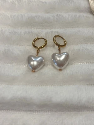 Guldörhängen med hjärtformade pärlor💞 - Snygga örhängen med guldfärgade ringar och hängande hjärtformade pärlor. Super fina och trendiga🤍🌸 Alla örhängen på sista bilden finns även att köpa i båda guld och silver🥰