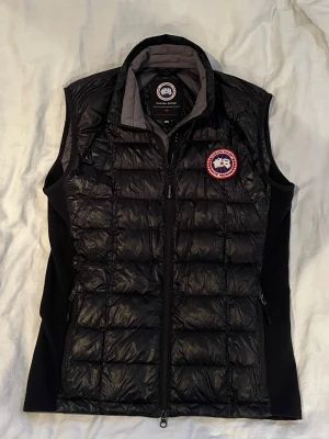  Canada Goose Väst - Säljer nu min svarta dunväst från Canada Goose då den inte kommer till användning längre.  Storlek M/M.                                                                Köpt för något år sedan från careofcarl.                                                                Vid frågor eller funderingar skriv.