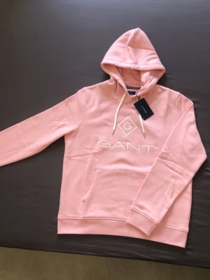GANT - Helt ny och oanvänd hoodie från GANT med etikett och originalpåse. Har en vit broderad logga på bröstet. Tillverkad i mjukt bomullsmaterial. 