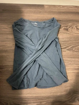 Dammblå långärmad topp Lager 157 - En enkel och stilren dammblå långärmad topp från Lager 157. Tillverkad i mjuk bomull med 5% elastan för extra stretch och komfort. Perfekt basplagg med rund hals och smal passform. Storlek M