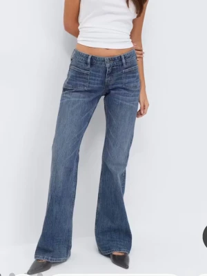 Blå bootcut jeans med fickor fram - Snygga blå bootcut jeans med flared ben och två framfickor. Jeansen har klassisk femficksdesign, bälteshällor och dragkedja med knapp. Perfekta för en avslappnad och trendig look.