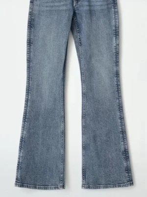 Blå utsvängda jeans med tvättad look - Säljer ett par blå jeans med utsvängda ben och snygg tvättad finish. Jeansen har klassisk femficksdesign och hög midja. Perfekta för dig som gillar retrostil och vill ha ett par bekväma och trendiga jeans i garderoben. ANVÄND BARA EN GÅNG