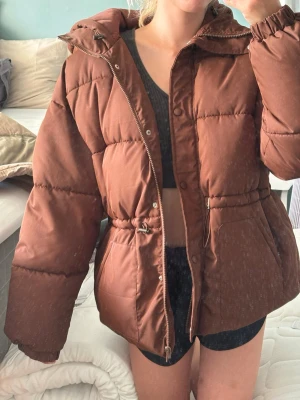 Brun Playboy pufferjacka - Pris går att diskuteras. Playboy x missguided. Köpte den vintern 2022 eller 2021. Knappt använd. Enbart lappen på innersidan som har släppt. Den är stor och mysig, jag är 175cm lång som referens. 