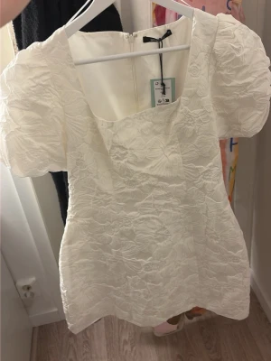 Vit kort klänning med puffärm - Säljer denna super fina klänningen ifrån Gina tricot, aldrig använd med prislapp kvar storlek 38