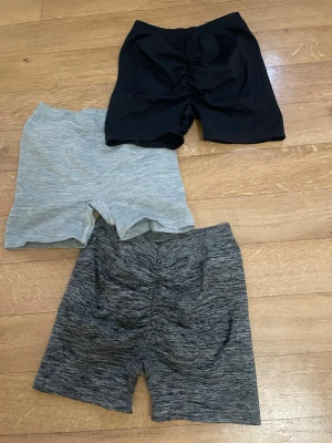 3-pack cykelshorts i olika färger - Tre par cykelshorts i svart, ljusgrått och mörkgrått melerat. De har en tight passform och är tillverkade i stretchigt material, perfekta för träning eller en sportig look. Shortsens midja är normal och de har en enkel, stilren design utan synliga detaljer. Sömlösa