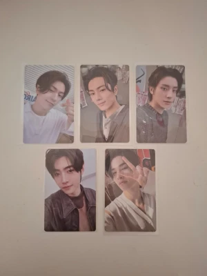 Romance: Untold photocard set - Säljer ett set med fem photocard från Romance: Untold. Korten har olika motiv på en kille i olika poser och outfits. Baksidan är vit med röd text. Perfekt för dig som samlar på K-pop eller vill ha snygga samlarkort till din kollektion.
