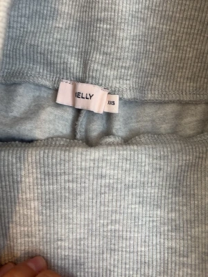 Grå ribbade mjukisbyxor från Nelly - Säljer ett par ljusgrå mjukisbyxor från Nelly i storlek XXS. Byxorna har ribbad struktur, bred resår i midjan och raka ben. Perfekta för chill dagar hemma eller när du vill vara extra bekväm. Materialet är mjukt och stretchigt för maximal komfort. Dessa är andända en gång för länge sen och dem är i helt ny kvalité och super fina på. Dem säljs ej längre på Nelly men jag tror orginall priset var samma som på de andra byxorna jag säljer från Nelly så 299kr