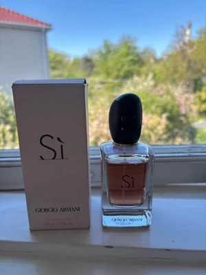Giorgio Armani Sì Eau de Parfum 50ml - Giorgio Armani Sì Eau de Parfum i elegant glasflaska med svart lock och ljusrosa doftvätska. Flaskan rymmer 50 ml och kommer med originalkartong. En klassisk och stilren parfym som passar perfekt i samlingen. Nypris: 950kr