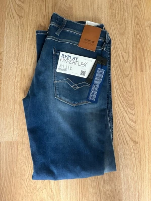 Blå Replay Hyperflex jeans. Helt nya!! - Snygga blå jeans från Replay Hyperflex med klassisk femficksmodell och raka ben. Jeansen har en lätt tvättad look och kontrastsömmar. Tillverkade i stretchigt material för extra komfort. Perfekta för dig som vill ha både stil och rörelsefrihet. Skick 10/10 helt nya!! Storlek W31, L30