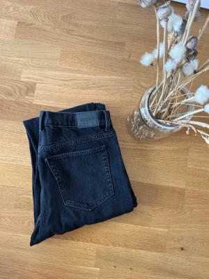 Svarta Barrel jeans från Weekday - Säljer ett par svarta Barrel jeans från Weekday. Jeansen har en avslappnad passform med hög midja och raka ben. Klassisk femficksmodell i kraftigt denimtyg. Perfekta för en cool och enkel stil.
