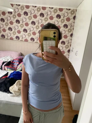 Ljusblå ärmlös topp - En enkel och stilren ljusblå topp med ärmlös design och rund halsringning. Toppen har en rak passform och är tillverkad i ett mjukt bomullsliknande material. Perfekt att matcha med jeans eller kjol för en avslappnad look.