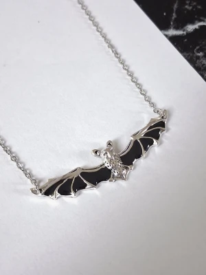 Halsband fladdermus  - Silvrigt halsband fladdermus med utsträckta vingar och svart emaljerad. Materialet rostfritt stål. 