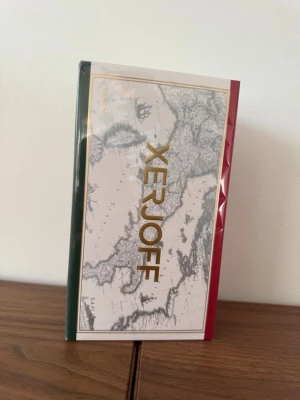 Xerjoff Renaissance Eau de Parfum - Lyxig parfym från Xerjoff i serien Renaissance. Förpackningen har en elegant design med gulddetaljer, karta på framsidan och färgerna grön, vit och röd. Flaskan innehåller 100 ml Eau de Parfum och är känd för sin exklusiva doftprofil.