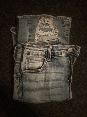 Ljusblå slitna jeans från SHEIN - Använda fåtal gånger så är i bra skick. High waist/mid waist bootcut med hål och slitningar på knäna, bakfickorna är lite mindre en standarden. Du betalar frakten.                                                              Det är bara att höra av sig om du har funderingar🤗