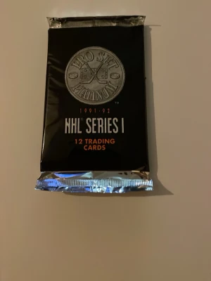 NHL Pro Set 1991-92 Series 1 kort - Oöppnat paket med 12 samlarkort från NHL Pro Set 1991-92 Series 1. Förpackningen är svart med silverdetaljer och logotyp framtill. Perfekt för dig som gillar hockey och samlarkort.