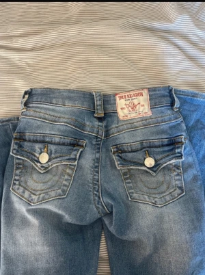 True Religion bootcut jeans ljusblå - Säljer ett par ljusblå bootcut jeans från True Religion! 💞 fint skick, har knappt använt jeansen ! priset kan absolut diskuteras🩷 i storlek 23, joey!