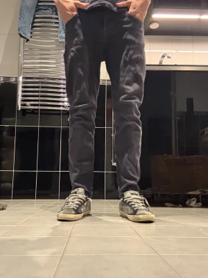 Mörkblå slim fit jeans herr - Säljer ett par svarta slim fit jeans med klassisk femficksmodell och normal midja. Jeansen har raka ben och är tillverkade i ett mjukt denimtyg som ger en skön passform. Perfekta för dig som gillar en enkel och stilren look. Modellen är 178 lång och väger 64 kilo hör av er vid intresse💪