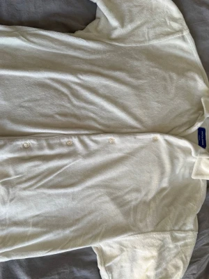Vit frottéskjorta från Jack & Jones - Snygg vit skjorta från Jack & Jones i mjuk frotté. Skjortan har klassisk krage, knäppning framtill och en avslappnad passform. Perfekt för en chill och trendig look. Kom med prisförslag 