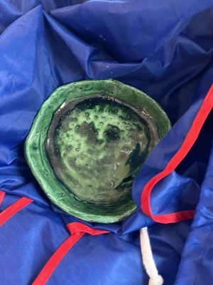 Grön keramikskål med unik form - Säljer en handgjord keramikskål i olika nyanser av grönt. Skålen har en organisk, oregelbunden form och en glaserad yta med prickigt mönster. Perfekt som dekoration eller för småsaker. Materialet är keramik.
