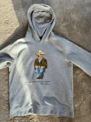 Grå hoodie Polo Bear Ralph Lauren - Storlek S/M, har använts ett par gånger men är fortfarande bra skick. Pris kan diskuteras vid snabb affär.