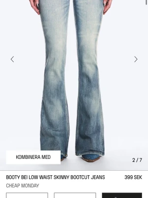 Ljusblå bootcut jeans med låg midja - Säljer ett par ljusblå bootcut jeans med låg midja och slitna detaljer. Jeansen har klassiska fem fickor och är tillverkade i denim med en snygg tvätt. Perfekta för en avslappnad och trendig look.
