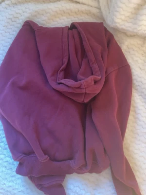 Vinröd hoodie - Mysig vinröd hoodie med stor huva och klassisk magficka framtill. Tröjan har ribbade muddar vid ärmslut och nederkant. Har använts 