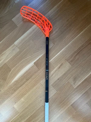 Unihoc MAX slim 29 flex svart/guld - Unihoc MAX innebandyklubba i 29 flex. Klubban är 96cm lång. På klubban sitter ett Unilite blad i neon orange PP-TI och en vit grepplinda. Klubban är endast använd en träning! Skaftet är ett slim skaft. Nypris ca 1500kr. Vid frågor eller funderingar är det bara att höra av sig. Pris kan diskuteras! 