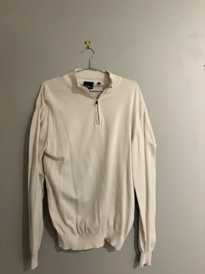 Vit halvzip-tröja från Oscar Jacobson - En snygg Halvzip från Oscar Jacobson med Créme vit färg. Helt nytt skick och aldrig använd.