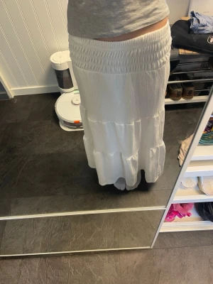 Lång vit kjol från Gina tricot - Säljer en långkjol från Gina tricot, storlek 146-152. Super fin kjol som bara använd nån enstaka gång.