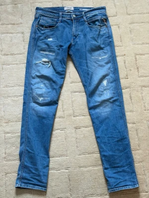 Replay - Ett par Replay jeans i helt nytt skick, knappt blivit använda pga att de varit för små för mig. Jeansen har storlek W31 L34 och de har riktigt feta slitningar. Skriv direkt vid funderingar, mått osv