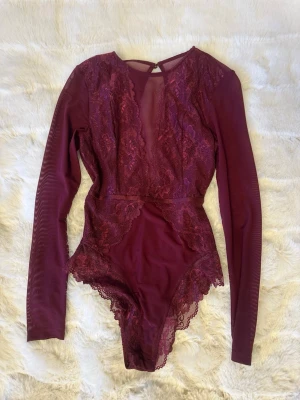 Vinröd spetsbody med långa ärmar - Säljer en vinröd body med långa ärmar.  