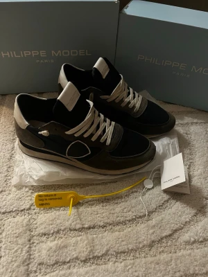 Philippe Model trainers  -  Riktigt feta trainers  från Philippe Model i marinblått och grått med vita detaljer. Skorna är för dig som vill ha en riktigt chill och stilren look