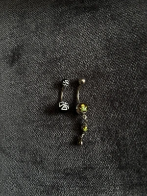 2 coola navelpiercingar  - 2 stycken navelpiercingar, den svarta med kors är ifrån punkt shop, den med döskallar är från en marknad🩷perfekt för en cool detalj till din outfit