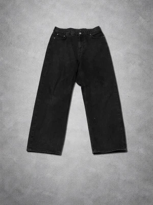 Svarta wide leg jeans Sweet Skts - Säljer ett par svarta wide leg jeans från Sweet Skts. Jeansen har hög midja, fem fickor och raka, vida ben. Materialet är kraftig denim i 100% bomull. Perfekta för en avslappnad och trendig look.