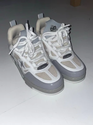 Lv skate, grå, stl 46 - Snygga sneakers i vitt, grått och beige från lv. Skorna har meshpaneler, rejäla vita snören och coola detaljer. Kombination av läder och mesh ger både stil och komfort. Perfekta för dig som gillar streetwear. Har du några frågar tveka inte att fråga! Du kan nå mig här på plick eller telefonnummer, 0707295611! 