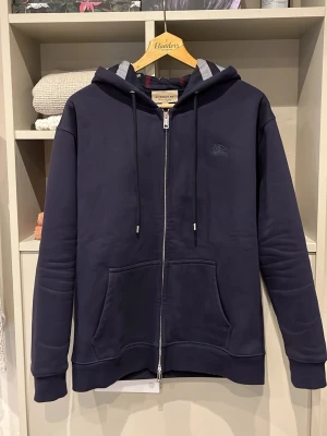 Blå Burberry Hoodie - Säljer denna riktigt fina o sällsynta ziphoodien från Burberry | Storlek S | Mått📏: ca 69 längd o 46 axel till axel | Tröjan är dubbeldragkedjad där det står ”burberry” på | Vid fler frågor hör gärna av er!🏌️