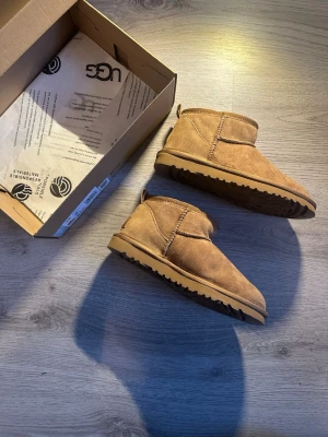 UGG Ultra Classic Mini dam boots Strl.38 - Äkta fårskinn, varma & korta vinterstövlar - Hej hej! Jag säljer ett par Ugg Classic Mini i äkta fårskinn med den låga skaftmodellen i storlek 39, men passar 40 också Mjuk och varm insida i ull som håller fötterna varma, särskilt nu under vintern! Yttermaterial i mocka och slitstark, lätt EVA-sula Bekväma, varma och perfekta för vardag under kallare dagar 
