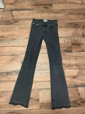 Svarta bootcut jeans med rå kant - Säljer ett par svarta bootcut jeans från Lager 157 med råa kanter nertill. Jeansen har klassisk femficksdesign, normal midja.