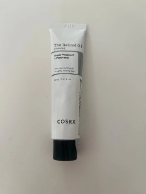 COSRX The Retinol 0.1 Cream - Retinolkräm från COSRX i en vit tub med svart skruvkork. Innehåller 0.1% retinol, super vitamin E och panthenol för fastare och slätare hud. Tuben rymmer 20 ml och är perfekt för dig som vill boosta hudens lyster och motverka ålderstecken. Fick i en kalender och är helt oanvänd!