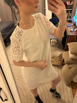 Zara Studentklänning❤️ - Säljer en vit kortklänning med raka linjer och fina spetsdetaljer på ärmarna. Klänningen har rund halsringning och är kortärmad med ett elegant, enkelt uttryck. Perfekt för dig som gillar stilrena plagg med en twist av spets. Använd 1 gång så superfin är den. (Tjejen på bild är 1.57 och är xs) Finns inte att köpa nånstans så passa på😊 Priset kan diskuteras