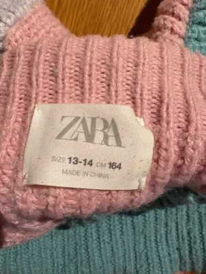 Flerfärgad stickad polotröja Zara - Säljer en ribbstickad polotröja från Zara i storlek 164. Tröjan har en cool färgblockdesign med mintgrön kropp, ljusrosa ärm, ljusgul ärm och rosa polokrage. Perfekt för dig som gillar färg och vill sticka ut lite extra. Unik tröja.