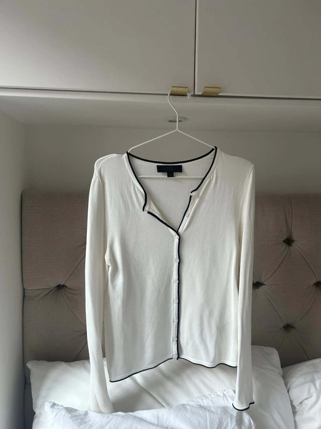 Vit kofta med svarta kanter