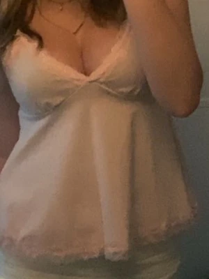 Ljusrosa spetsbody med v-ringning - Söt ljusrosa body med v-ringning och spetsdetaljer längs urringning och nederkant. Tunn och mjuk känsla, perfekt för att känna sig extra fin. Ärmlös och med feminina detaljer som ger en romantisk vibe. Men nypris är 250kr