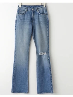 Blås bootcut jeans med hål - Säljer ett par blå bootcut jeans med slitning vid knät. Jeansen är midwaist och storlek 34, säljer då jag inte får på mig dom längre! ❤️de är från Gina tricot 