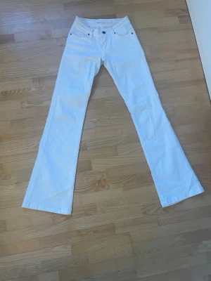 Subdued bootcut jeans - Vita lågmidjade bootcut jeans från Subdued med svagt mönster på fickorna. Använt kanske två gånger💕skulle säga att storleken är 32/34!