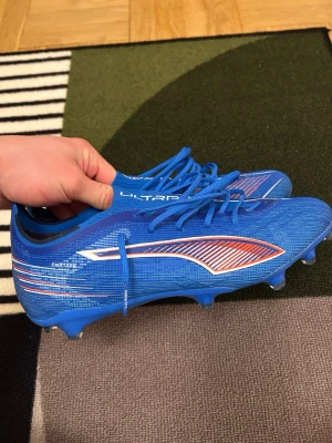 Puma ultra 6 fg/ag - Säljer ett par snygga blåa Puma Ultra fotbollsskor då dom är för små. De är endast använda 1 gång under uppvärmning. Hör gärna av dig om du är intresserad eller vill ha fler bilder! Kom gärna med bud!